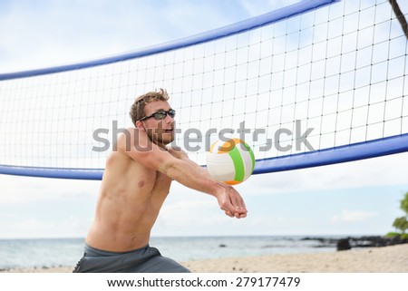 Beach volleyball man playing game hitting forearm pass volley ball during match on summer beach. Male model living healthy active lifestyle doing sport on beach.