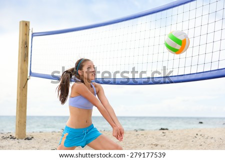 Beach volleyball woman playing game hitting forearm pass volley ball during match on summer beach. Female model living healthy active lifestyle doing sport on beach.