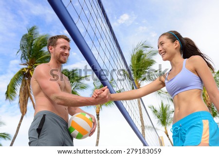 Handshake people in beach volleyball shaking hands after volley ball game on summer beach. Man and woman model living healthy active fitness lifestyle doing sport on beach.