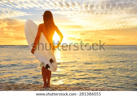 Surfing surfer girl looking at ocean beach sunset. Silhouette of female bikini woman looking at water with standing with surfboard having fun living healthy active lifestyle. Water sports with model.