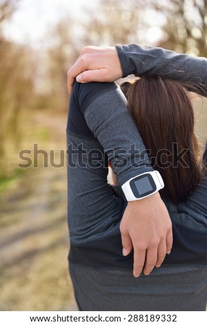 Smartwatch woman running with heart rate monitor. Closeup of female wrist wearing smart sport watch as activity tracker outdoors during cardio workout. Fitness girl stretching triceps during workout.
