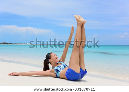 Abs exercise fitness woman - toe touch crunchesFitness woman training abs with toe touch crunches. Young adult Asian girl doing abdominal exercises