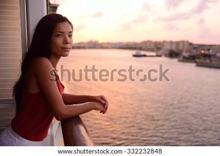 Cruise ship vacation woman enjoying balcony at sea with beautiful sunset on travel at sea. Relaxed woman enjoying private balcony in stateroom. Asian Chinese / Caucasian woman in dress on cruise liner