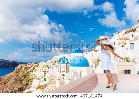 Europe tourist travel woman in Oia, Santorini, Greece. Happy young woman looking at famous blue dome church landmark destination. Beautiful girl in white dress on visiting the Greek island.