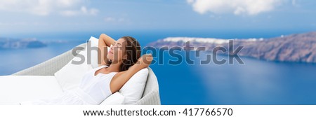 Relaxing woman sleeping on outdoor daybed patio furniture enjoying view of Mediterranean sea Europe travel destination. Asian girl lying down on pillows dreaming carefree happy. Luxury home living.