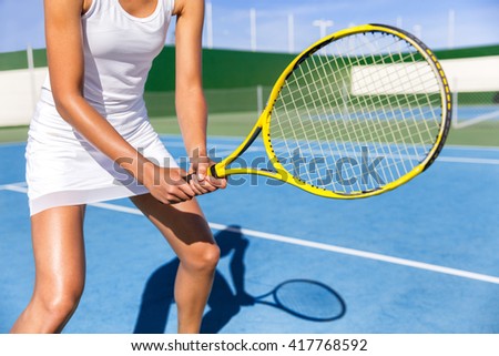 Midsection of tennis player woman ready playing game on blue hard court outdoor in position holding racket wearing white dress skirt. Female athlete sporty girl for summer sports activity course.