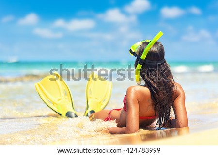 Beach vacation snorkel girl snorkeling with mask and fins. Bikini woman relaxing on summer holidays lying down in water after snorkelling with snorkel tuba and flippers sun tanning.