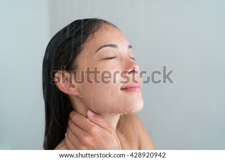 Shower woman showering relaxing under water massaging neck in hot shower. Asian female adult face enjoying spa relaxation time relaxing meditating in warm bath cleaning face and body at home.