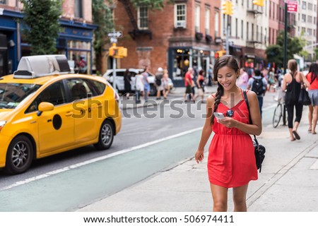 Woman walking in new york city using phone app for taxi ride hailing service or playing online game while commuting from work. Asian girl tourist searching for map directions on smartphone.
