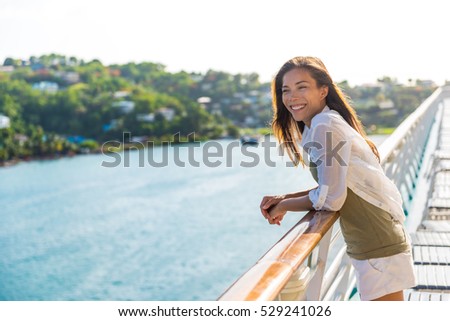 Cruise ship vacation Asian woman relaxing on deck enjoying view from boat of port of call city on St. Lucia island in the Caribbean. Happy casual tourist girl outside on tropical holiday destination.