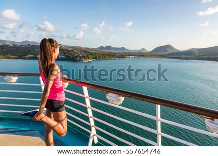 Fitness runner training stretching leg warm-up stretches before running on tracks of cruise ship boat. Woman enjoying view from deck of port of call Castries in St Lucia.