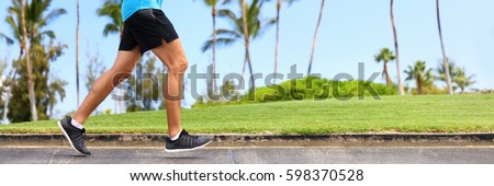 Fitness man athlete runner jogging on park sidewalk. Person running working out living an active lifestyle training cardio in summer in sportswear and shoes. Lower body banner crop.