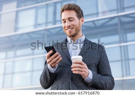 Business man looking at phone texting sms message text drinking coffee on morning break at work office. Businessman lifestyle.
