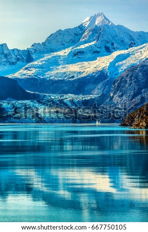 Glacier Bay Alaska cruise vacation travel. Global warming and climate change concept with melting ice. Cruising boat towards landscape of Johns Hopkins Glacier and Mount Fairweather Range mountains.