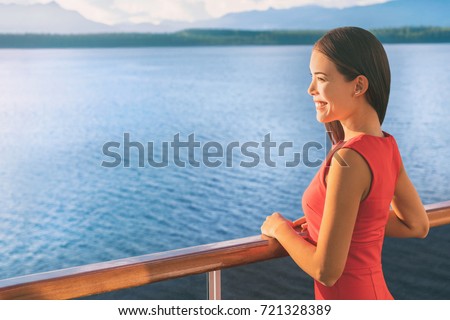 Cruise ship Alaska travel vacation woman on luxury boat. Asian elegant lady looking at sunset view of ocean from balcony deck.