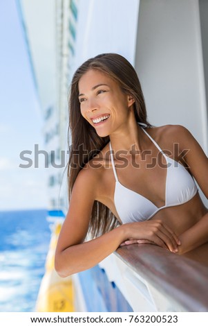Happy summer vacation fun bikini woman relaxing on cruise ship getaway vacation. Asian girl ready for the beach at Caribbean holiday travel on boat. Island hopping cruising.
