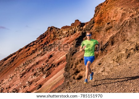Trail runner man athlete ultra running in mountain rocky path in nature. Volcano mountains backcountry landscape. Fitness and sports active lifestyle.
