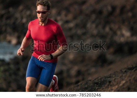 Fitness runner man sport athlete ultra running on endurance tough mud trail race competition training cardio jogging in mountain. Dark exposure of male adult in compression clothes, sunglasses.