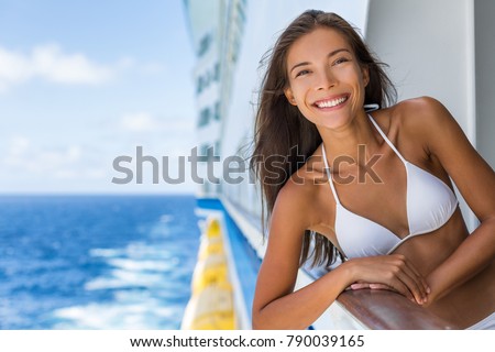 Cruise ship Caribbean travel vacation Asian woman tourist in bikini enjoying deck on troipcal holiday. Smiling happy girl having fun on boat. Portrait lifestyle.
