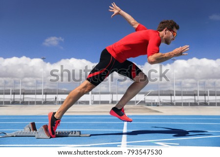 Runner athlete starting running at start of run track on blue running tracks at outdoor athletics and fiel stadium. Sprinter. Sport and fitness man running sprinting.