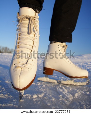 Closeup of figure skating ice skates in action outdoors