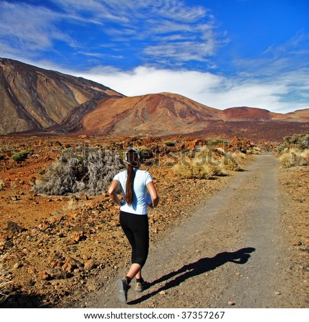 Runner, Woman running on dirt road in amazing volcano landscape on Tenerife.