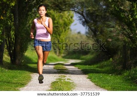Asian woman active in forest. running. Girl running at great speed. Freeze action image on beautiful forest path. Beautiful female model.
