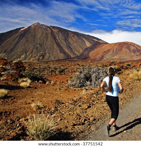 Running / jogging. Woman running on dirt road in amazing volcano landscape on Tenerife.