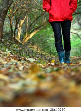 Autumn walk with copy space. Woman walking in the forest on a beautiful fall day.