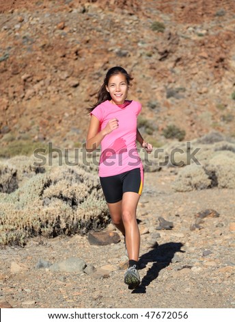Woman running. Female trail runner running on volcano. Beautiful mixed race chinese / caucasian.