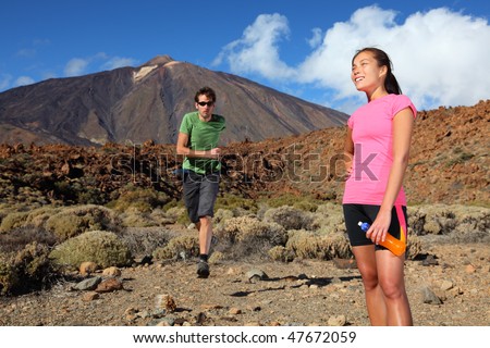 Running. Couple trail running in spectacular volcano landscape on Teide, Tenerife.