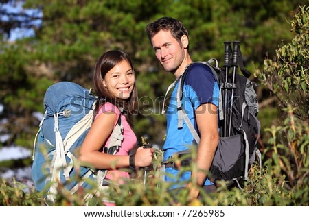 Happy hiking couple smiling during hike in forest on Tenerife, Canary Islands, Spain. Mixed race couple.