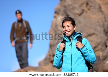 Hiking people. Hiker woman portrait outdoors in mountain scenery. Man in background.