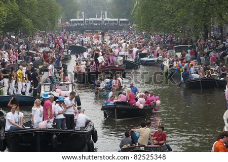 AMSTERDAM, THE NETHERLANDS - AUGUST 6: Crowd on boats in the Amsterdam canals during the famous Canal Parade of the Amsterdam Gay Pride 2011 on August 6, 2011 in Amsterdam.