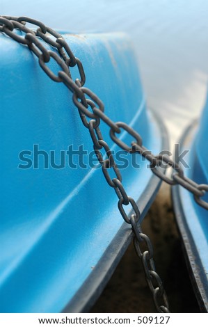Paddle boat chained up on shore