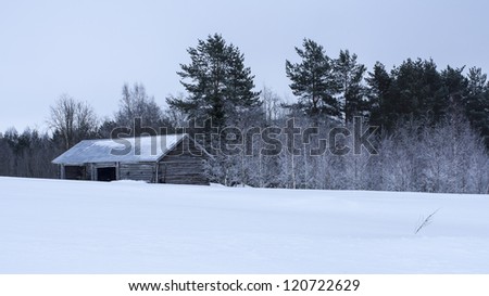 wooden barn at winter in finland