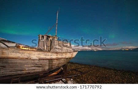 Old ship on the background of the Northern Lights in Tromso, Norway
