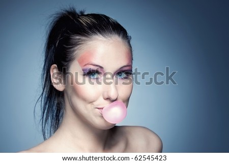 A fun young woman chewing bubble gum.