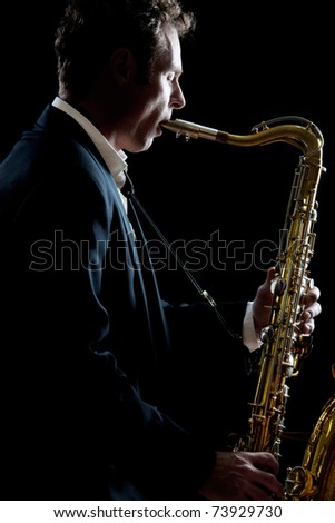 A smartly dressed saxophone player in a dark club setting