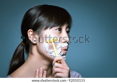 stock photo A young Asian girl shaving in a funny role reversal