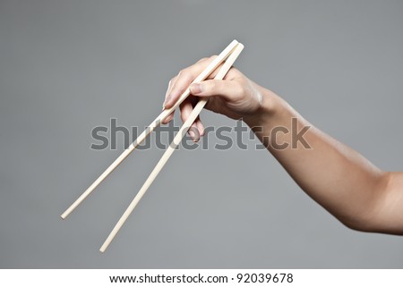 A female hand demonstrating correct oriental chopstick use in open position