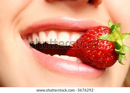 beautiful lips holding a strawberry