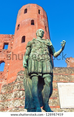 Ancient roman statue of emperor Augustus in front of Porte Palatine city gates, Turin, Italy