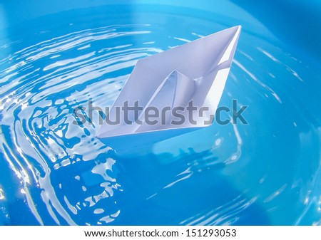 A toy paper ship in real water pond