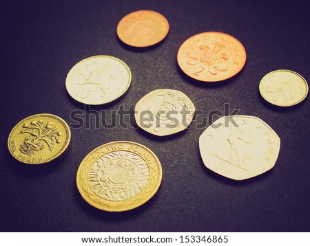 Vintage looking British Pounds coins (UK currency) over a dark background