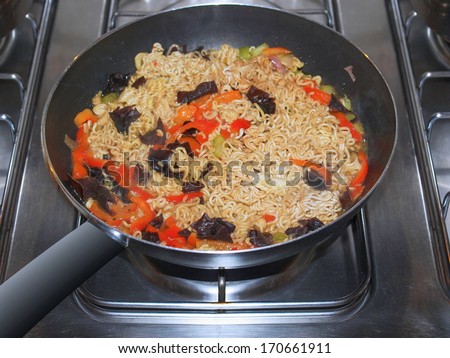 Curry noodles pasta traditional Indian and Japanese Asian food in a wok pan