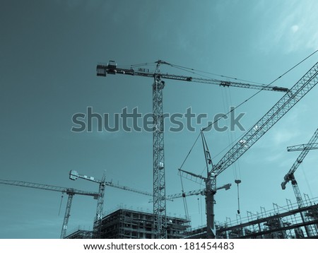 Construction crane for heavy weights lifting in building sites - cool cyanotype