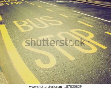 Vintage retro looking Yellow painted bus stop sign on a street