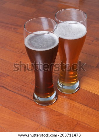 Two glasses of German dark and white weizen beer on the floor for a romantic rendezvous
