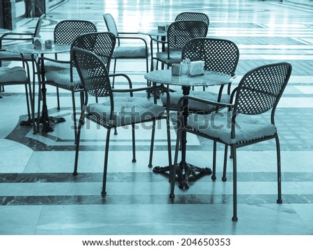 Tables and chairs of a dehors alfresco bar restaurant pub - cool cyanotype